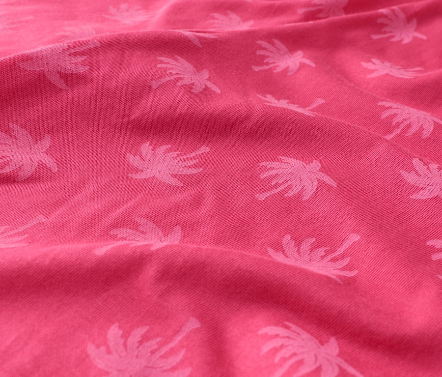 Nahaufnahme eines pinkfarbenen Stoffes mit Palmenmuster.
