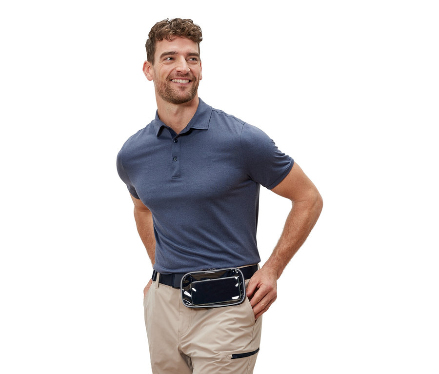 Ein Mann mit einem schwarzen Gürtel und einer transparenten Tasche lächelt.