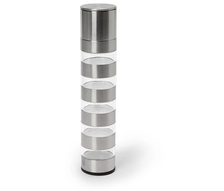 Eine Gewürzmühle aus Edelstahl und Glas steht auf einem weißen Untergrund.