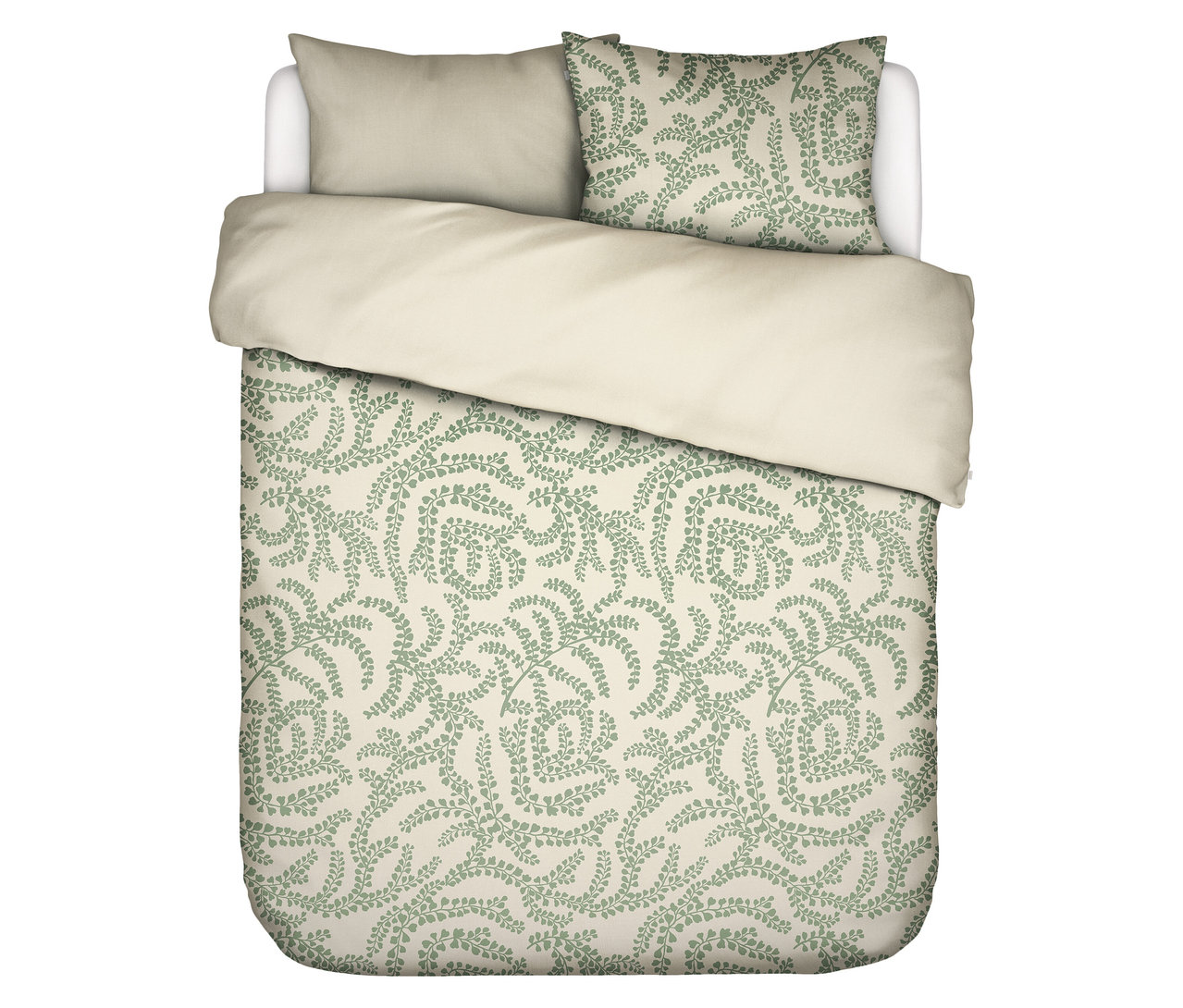 Draufsicht auf ein Bett mit hellbeiger Bettwäsche und einem Kissen mit grünem Farnmuster.