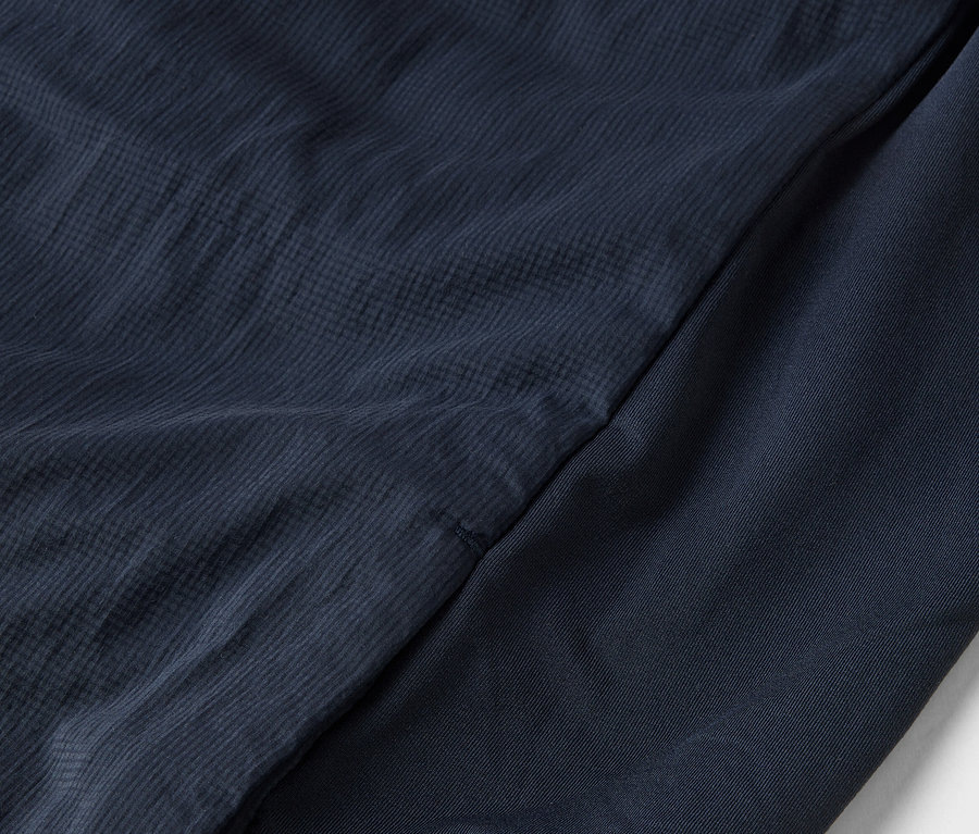 Detailaufnahme von marineblauem Stoff mit verschiedenen Texturen.