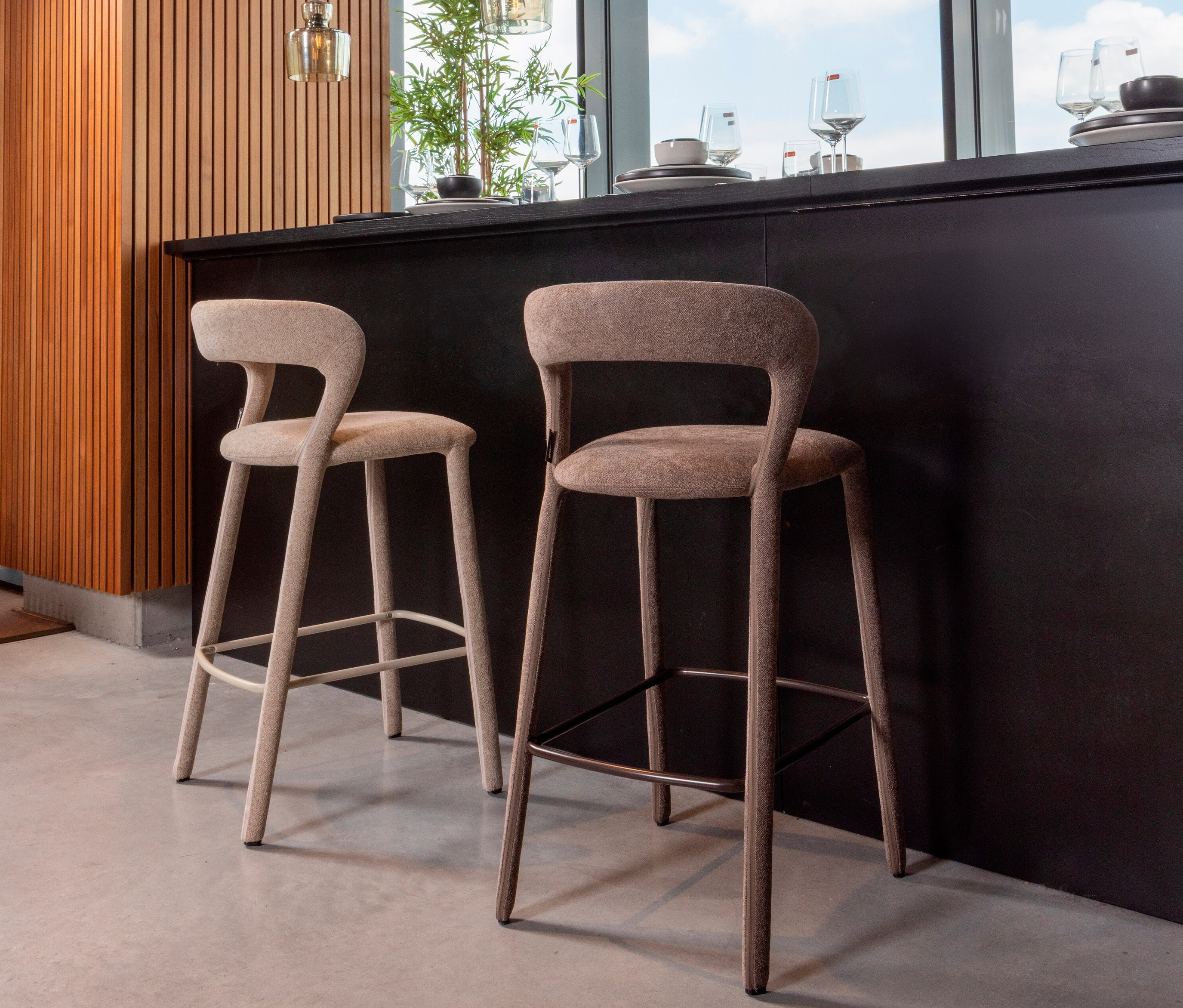 Zwei beige Barhocker stehen vor einer Küchentheke.