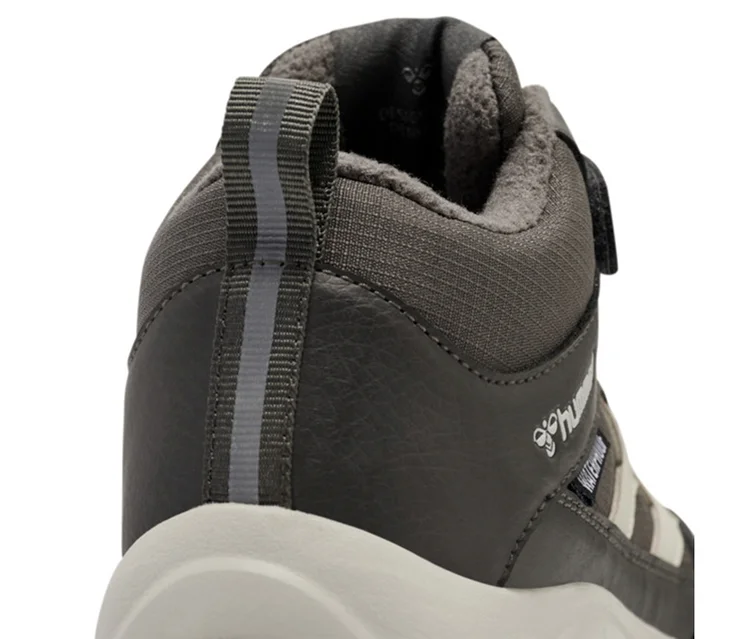 Dunkelgrauer hummel® Turnschuh »Root Tex Jr« mit hellem Sohlenrand, Zugschlaufe an der Ferse und „WATERPROOF“-Schriftzug an der Seite.