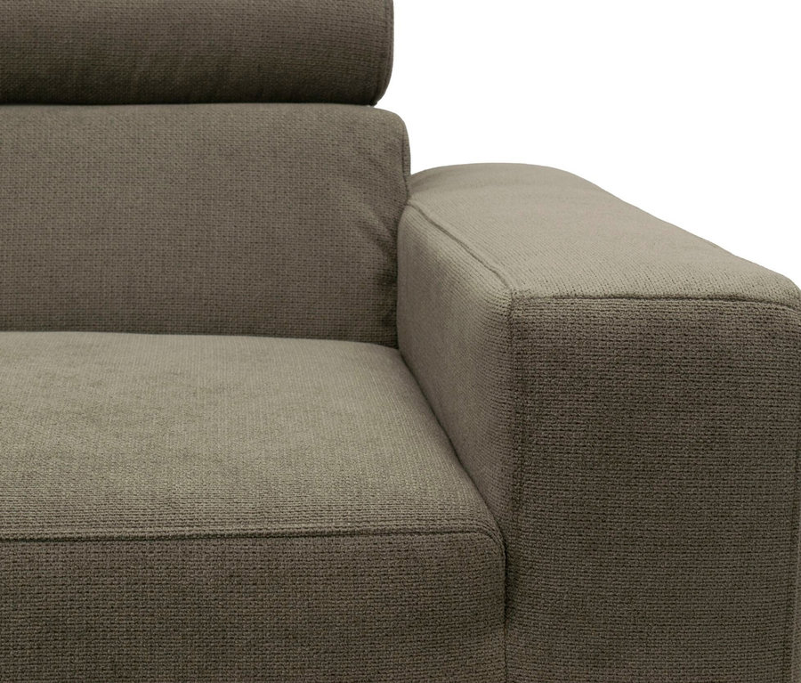 Nahaufnahme eines braunen Stoffsofas mit strukturierter Armlehne, Sitzfläche und Rückenlehne.