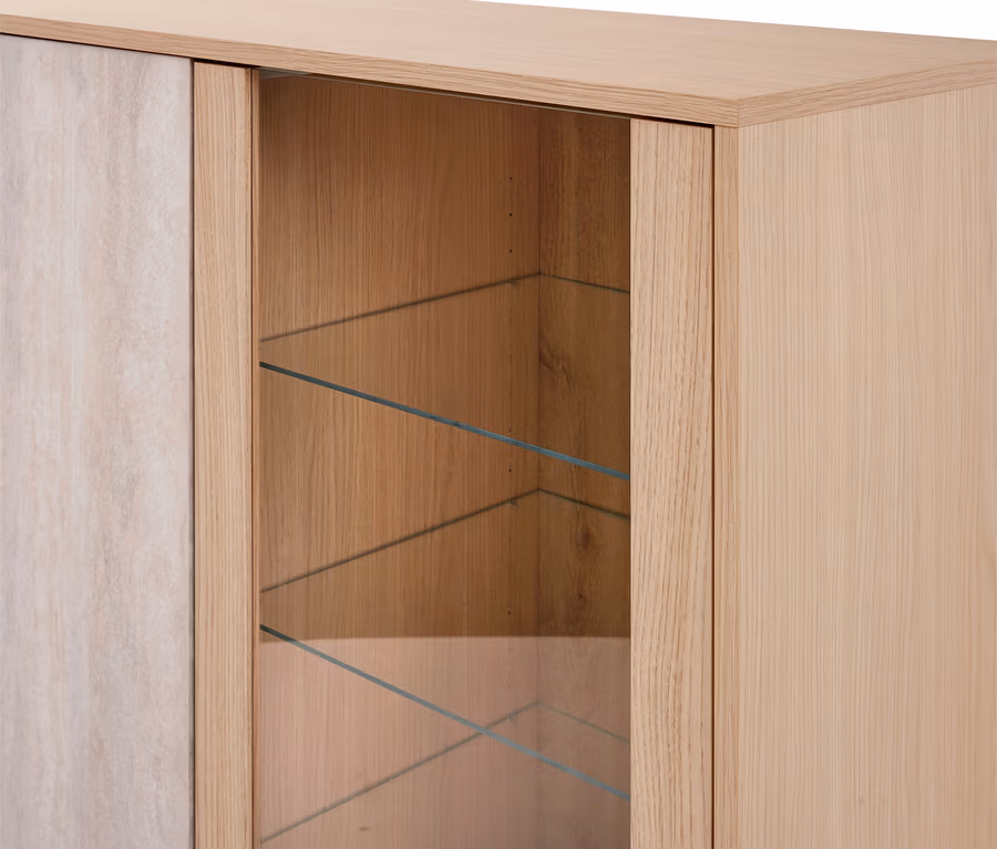 Nahaufnahme eines hellen Holzschranks mit einem Glasvitrinenbereich und drei Glasböden. Links ist eine massive Holzplatte sichtbar.