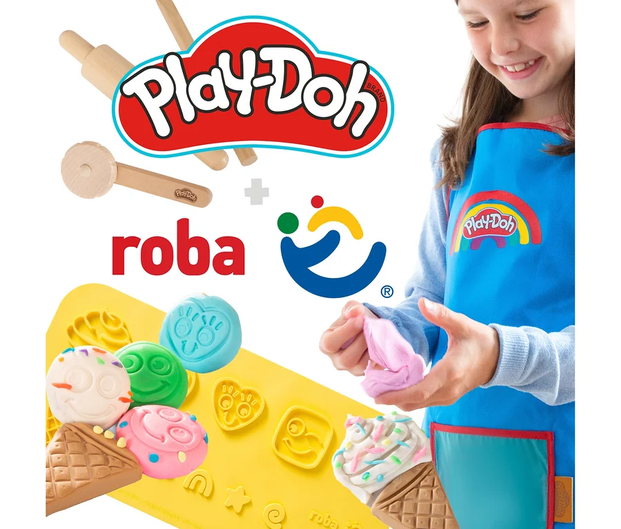 Ein Mädchen spielt mit Play-Doh Knete und formt Figuren auf einer gelben Unterlage. Sie trägt eine blaue Play-Doh Schürze.