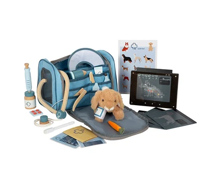 Ein 'small foot Tierarzt-Tasche mit Hase' Set liegt auf einem Tisch, inklusive Hasen Stofftier, Spielzeugspritze, Stethoskop und Röntgenbildern.