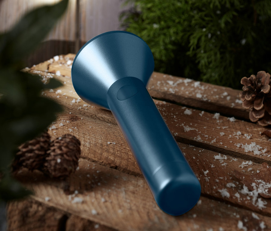 Eine blaue LED-Taschenlampe liegt auf einem Holztisch.