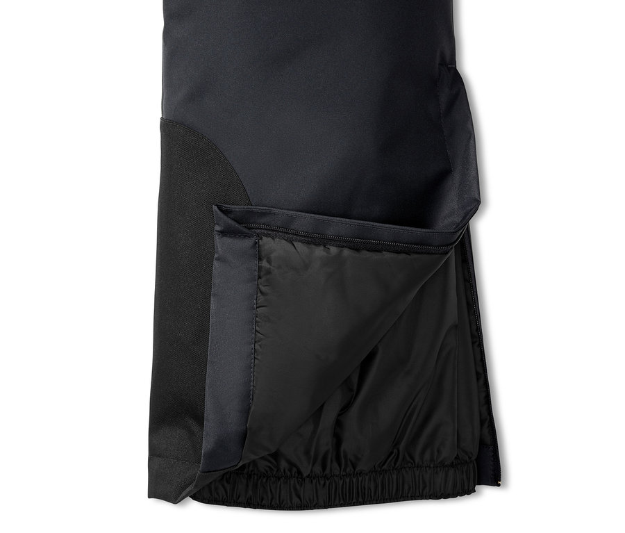 Detailaufnahme einer schwarzen Skihose mit geöffnetem Reißverschluss am Bein.