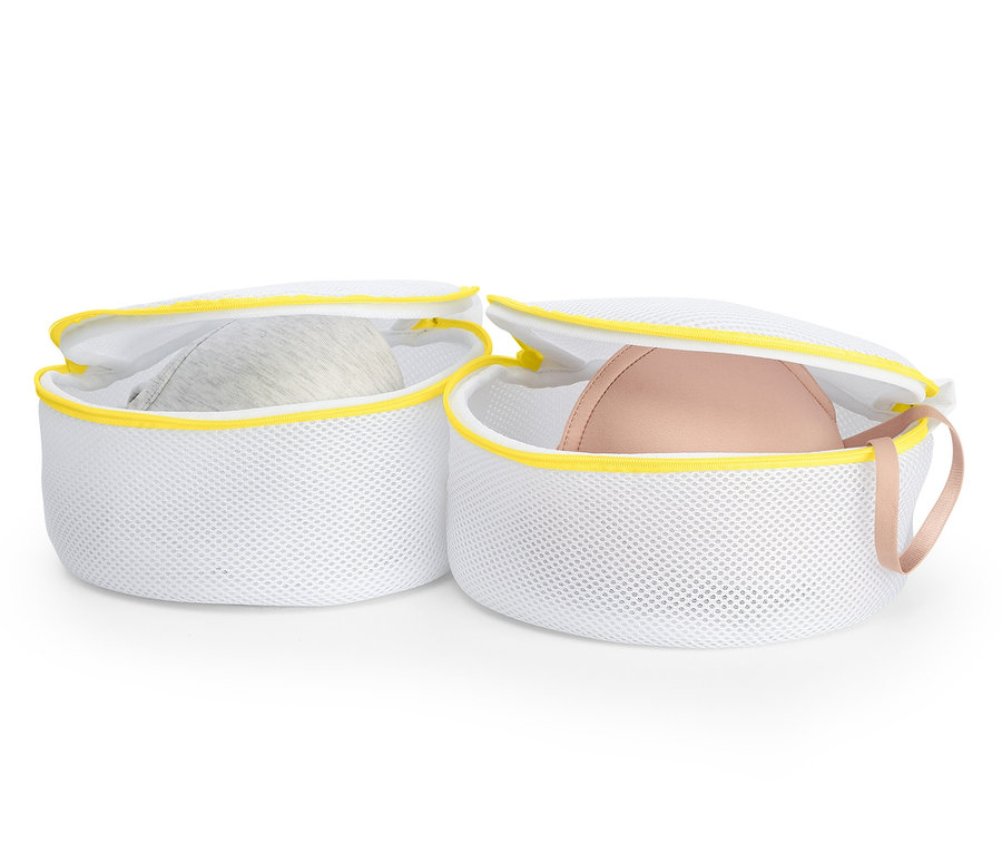 Zwei weiße BH-Wäschenetze mit Bügel-BHs, 2 BH-Wäschenetze, einer grau und einer pink.