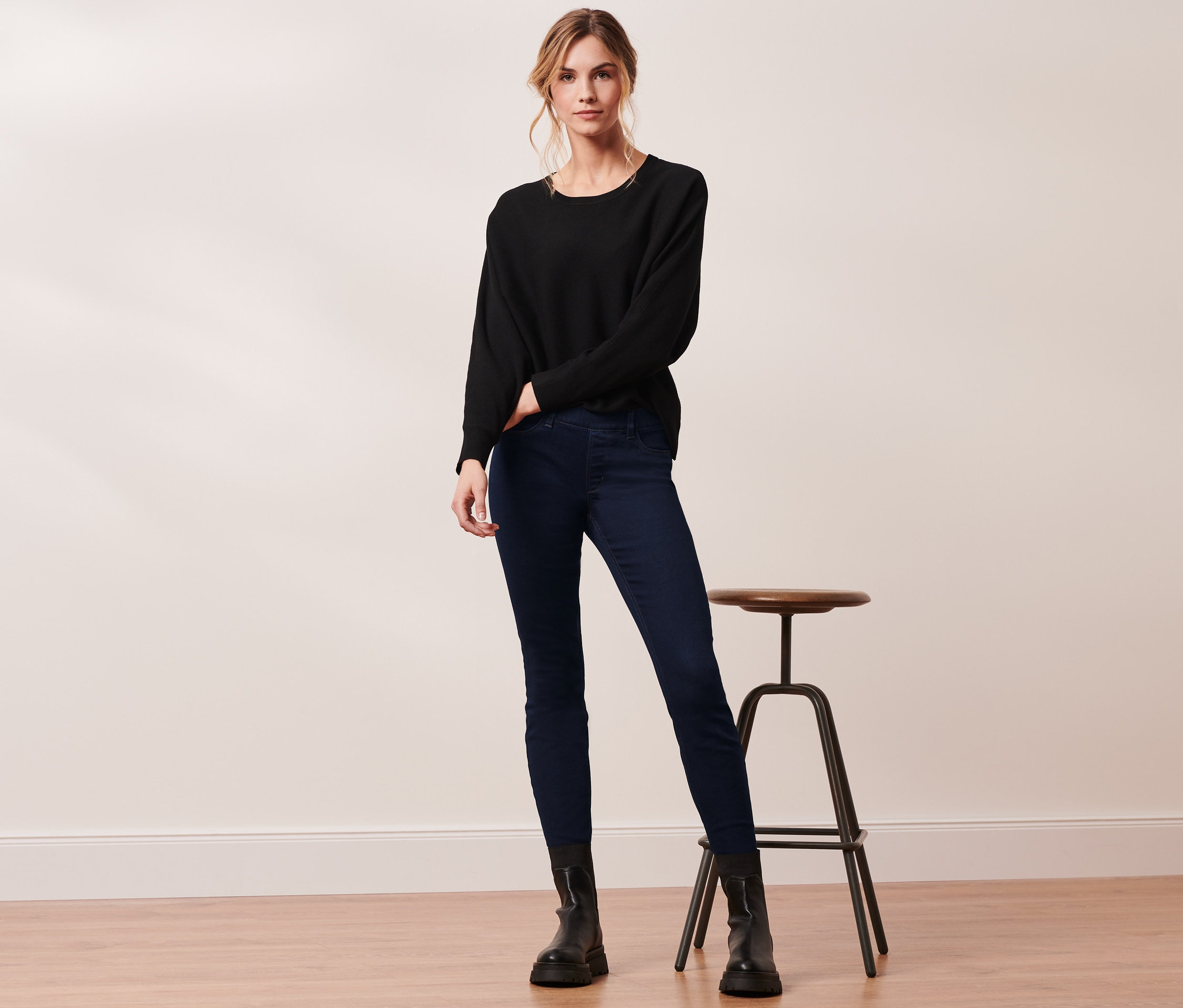 Frau posiert in schwarzem Pullover und Thermotreggings.