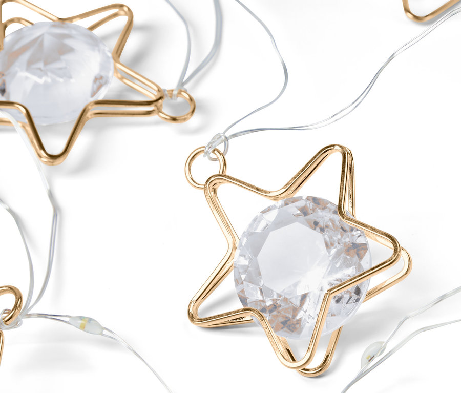 Nahaufnahme einer LED-Lichterkette mit sternförmigen goldenen Rahmen und klaren Edelsteinen.