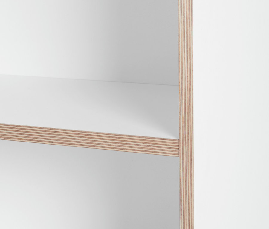 Detailaufnahme eines weißen Regals mit Holzkante.