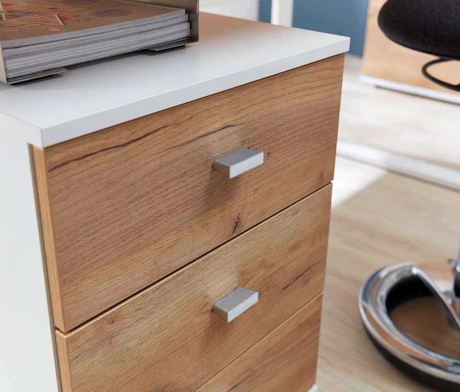 Detailansicht eines Rollcontainers »Lioni« mit Holzschubladen und weißer Oberseite, darauf eine Metall-Dokumentenablage.