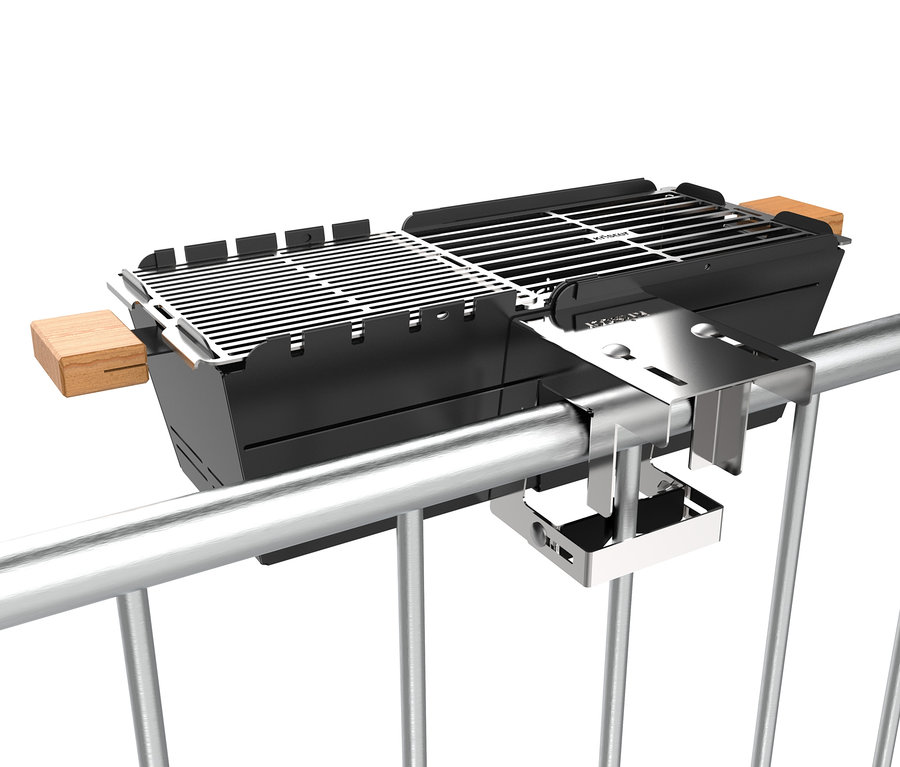 Ein schwarzer Knister Grill ist an einem silbernen Balkongeländer befestigt.