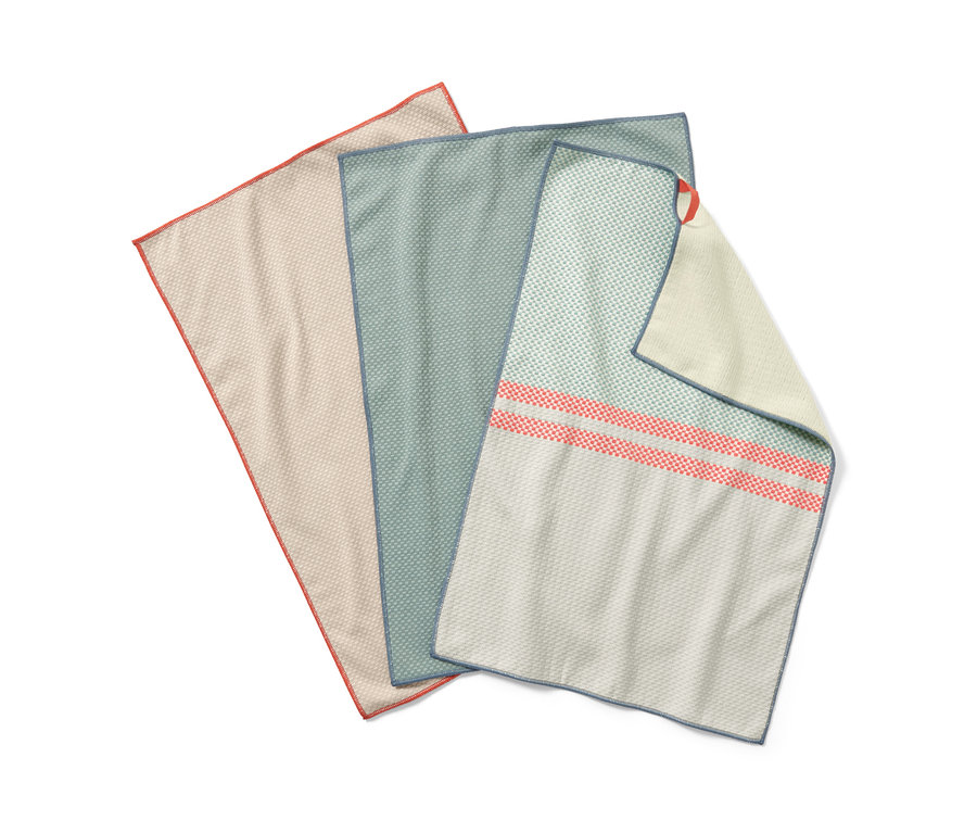 Drei Geschirrtücher liegen nebeneinander. Eines ist beige mit rotem Saum, eines grün mit blauem Saum und eines weiß mit roten Streifen.