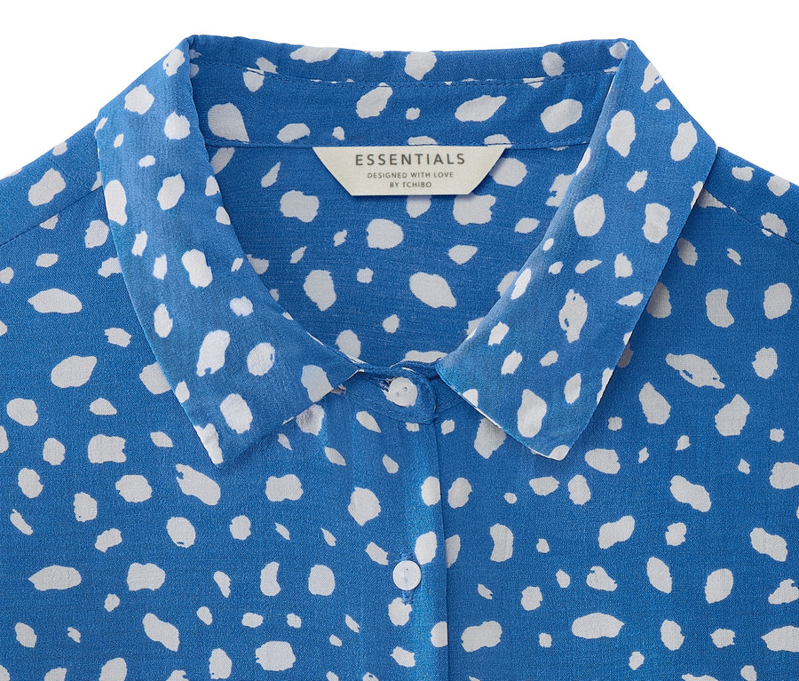 Detailansicht eines blauen Kleides mit Print.