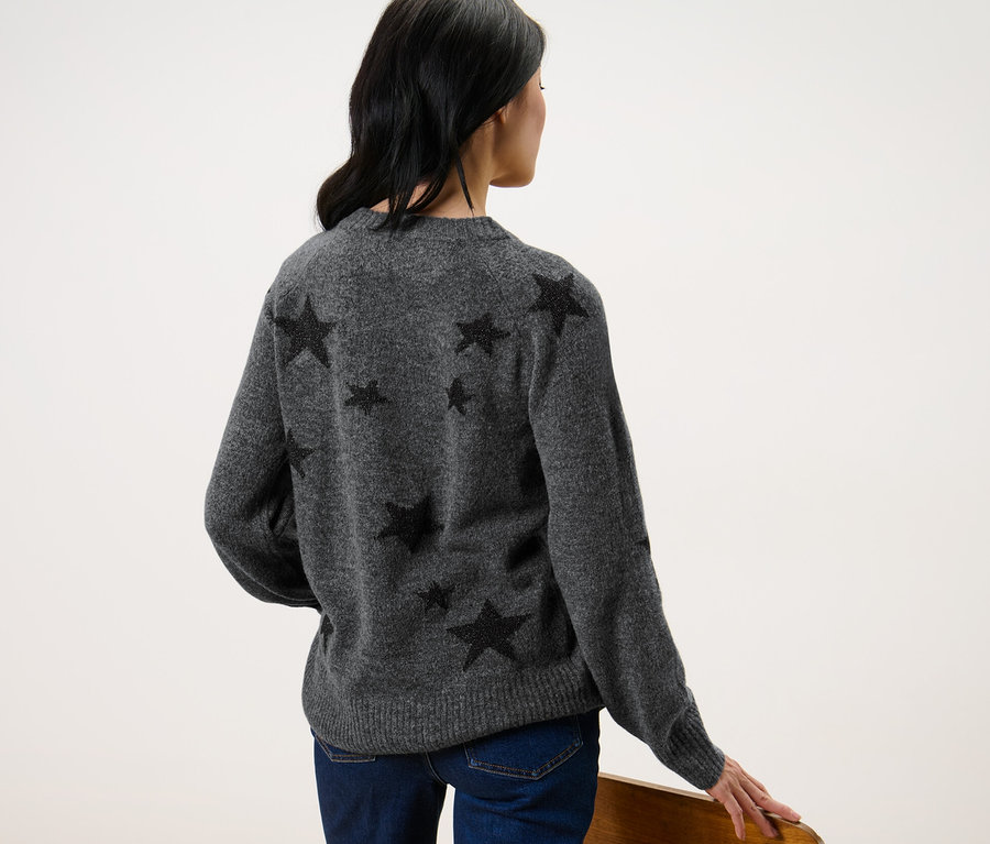 Frau trägt Strickpullover mit Sternen.