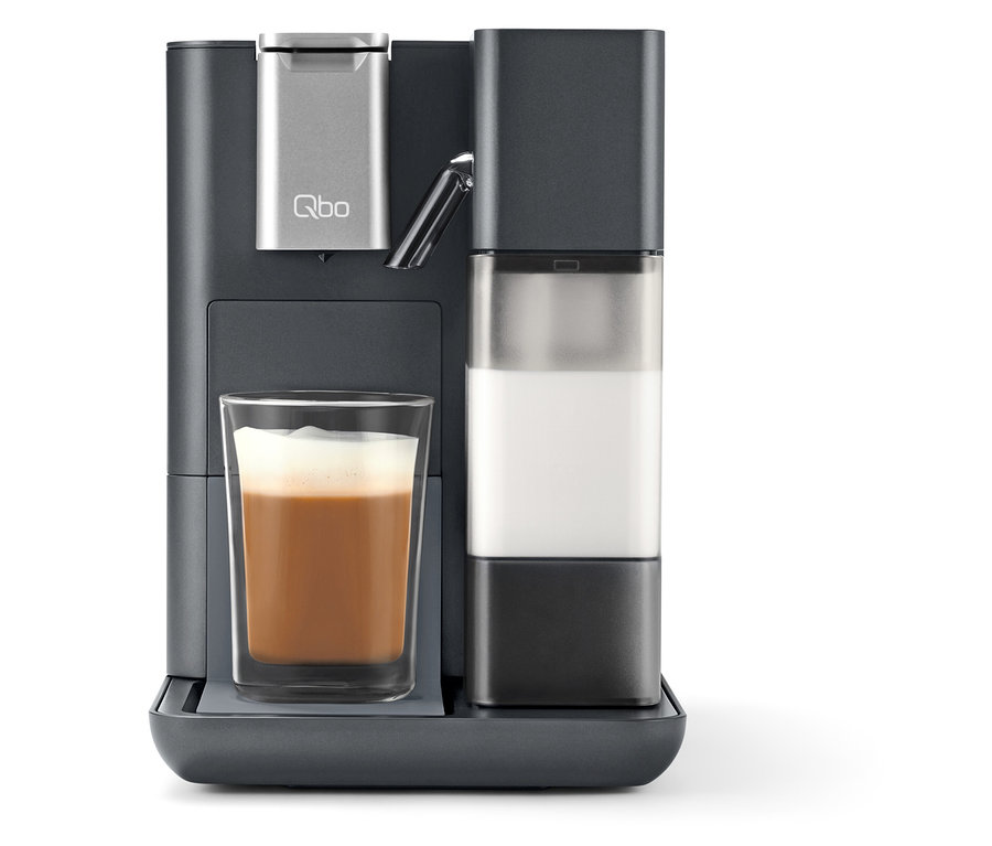 Ein grauer Qbo MILK MASTER mit Milchbehälter und einem mit Kaffee gefüllten Glas.