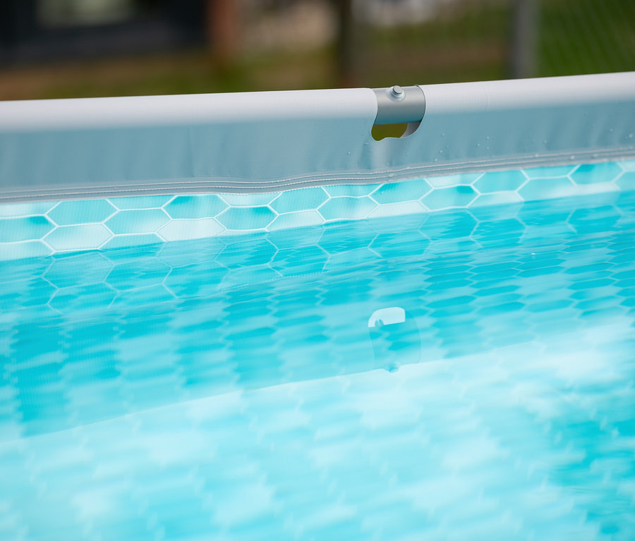 Detailansicht des oberen Teils eines Summer Waves Active-Frame-Pools mit blauem Wasser und einem Sechseckmuster.