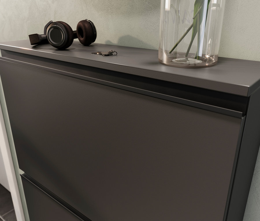 Auf der Oberseite des Schuhschranks »Kipper« in Graphit liegen Kopfhörer, Schlüssel und eine Vase mit einer Pflanze.