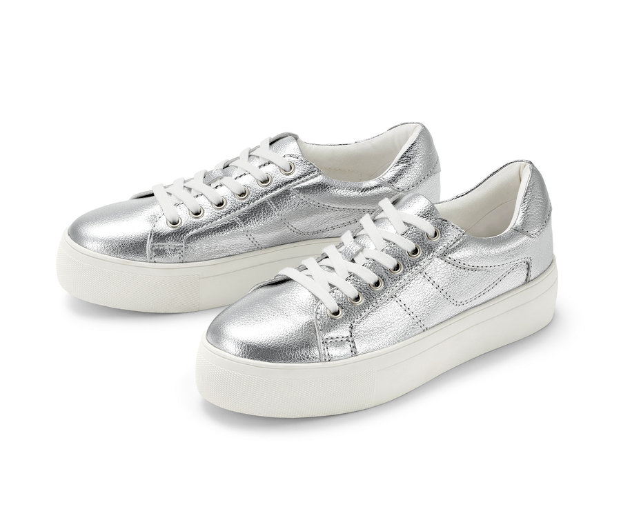 Zwei silberne Plateau-Sneaker aus Leder liegen nebeneinander auf einem weißen Hintergrund.