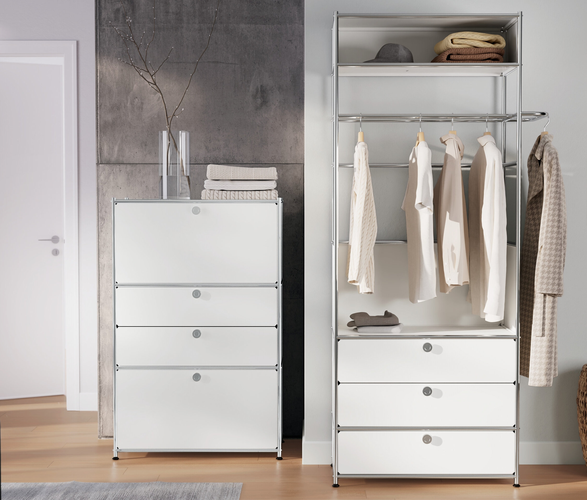 Im Raum stehen eine Garderobe Metall »CN3« mit Kleiderstange und 3 Schubladen und eine Kommode Metall »CN3« mit 2 Klappenfächern und 2 Schubladen, weiß.