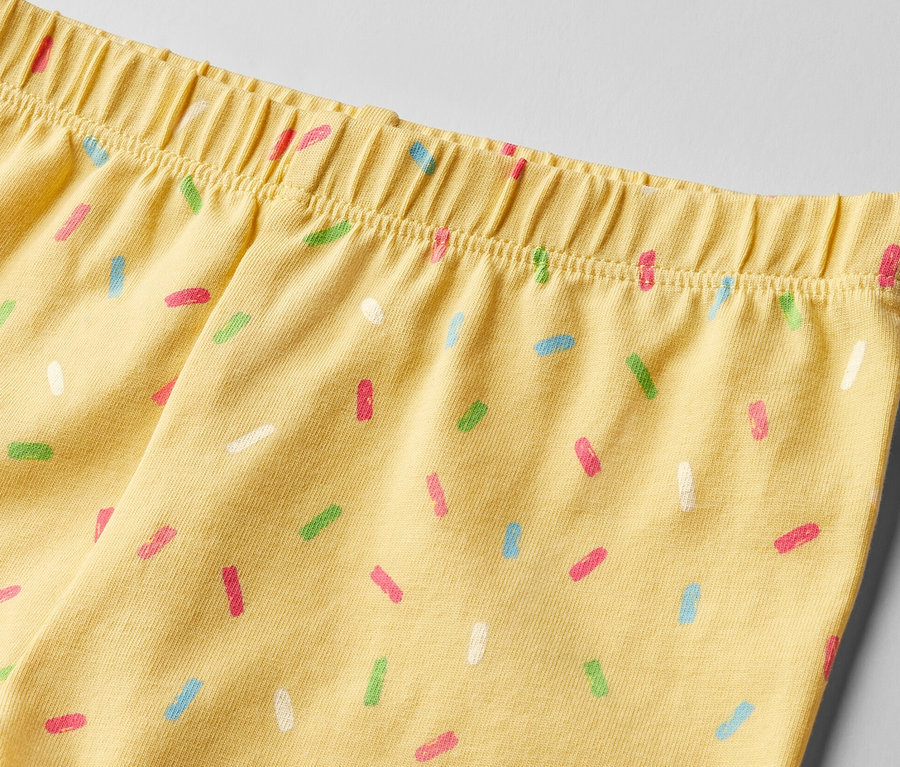 Detailansicht von gelben Kinder-Radler-Leggings mit bunten Streuseln, 2er-Pack.