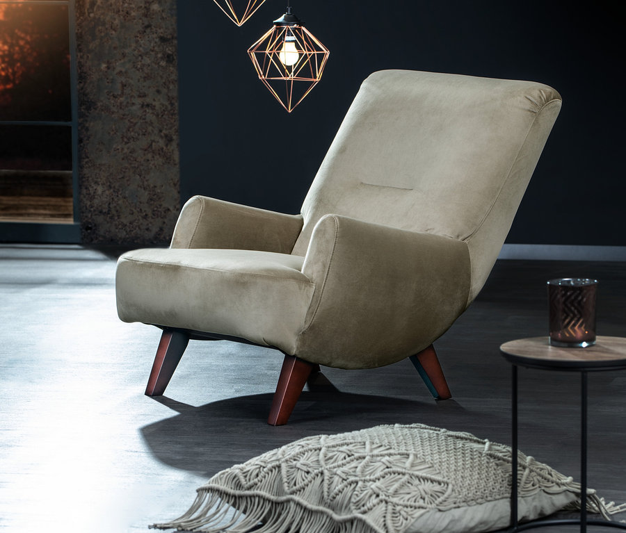 Ein »Borano« Sessel in Greige steht im Wohnzimmer neben einem Tisch und einem Dekokissen.