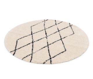 Ein beiger, ovaler Teppich mit einem schwarzen Rautenmuster.