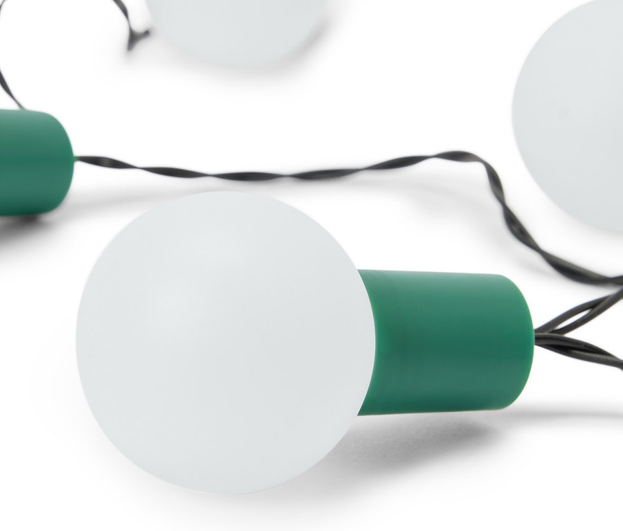 Nahaufnahme einer LED-Lichterkette mit weißen Glühbirnen und grünen Fassungen auf weißem Hintergrund.
