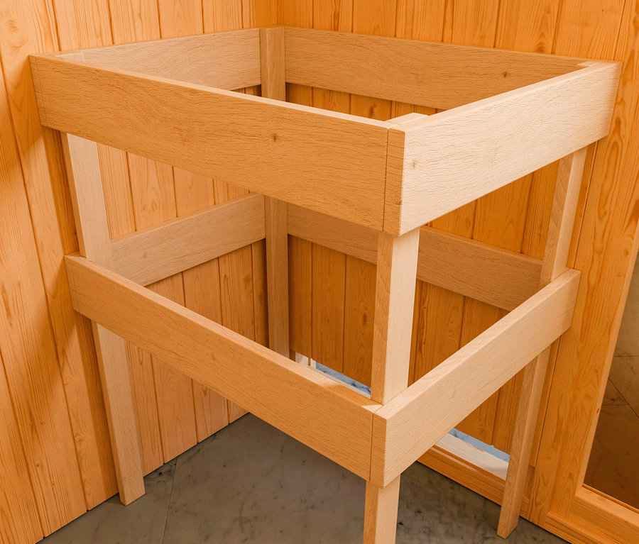 Unfertige Holzkonstruktion einer Karibu Sauna »Elli 2« steht im Inneren einer Sauna mit Holzwänden.
