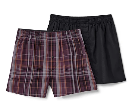 Zwei Webboxershorts, eine kariert, eine schwarz.