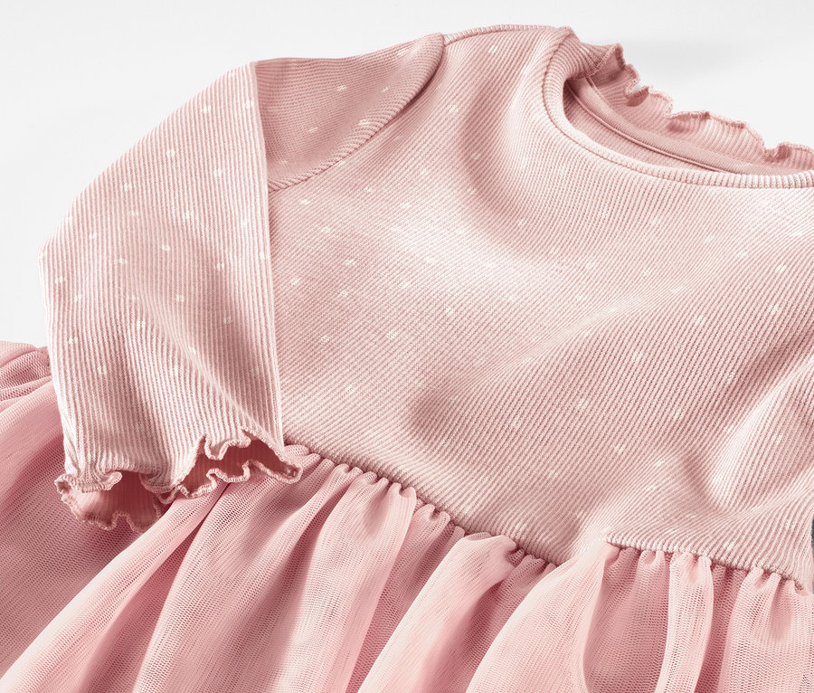 Detailaufnahme eines rosa Kinder-Rippkleides mit langen Ärmeln und Tüllrock.