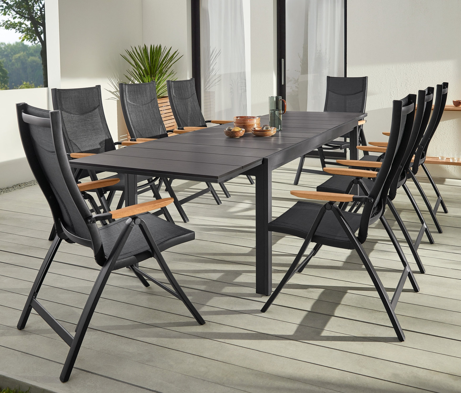 Schwarzer Ausziehtisch aus robustem Duraboard mit zwei LED-Akku-Tischleuchten und Hochlehner mit verstellbarer Rückenlehne.