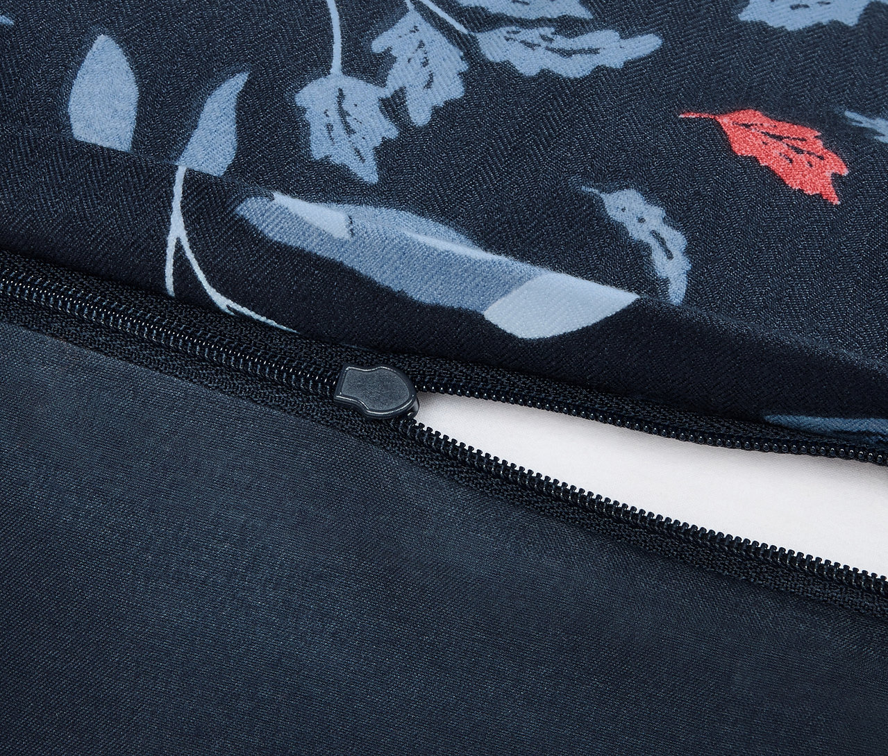 Detailaufnahme eines Baumwollbettbezugs mit Blumendruck und Reißverschluss.