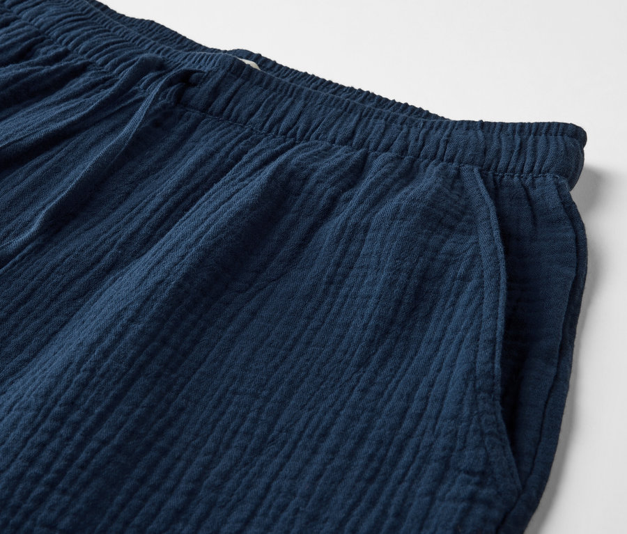 Detailaufnahme einer marineblauen Musselin-Shorts mit Gummibund und Tasche.