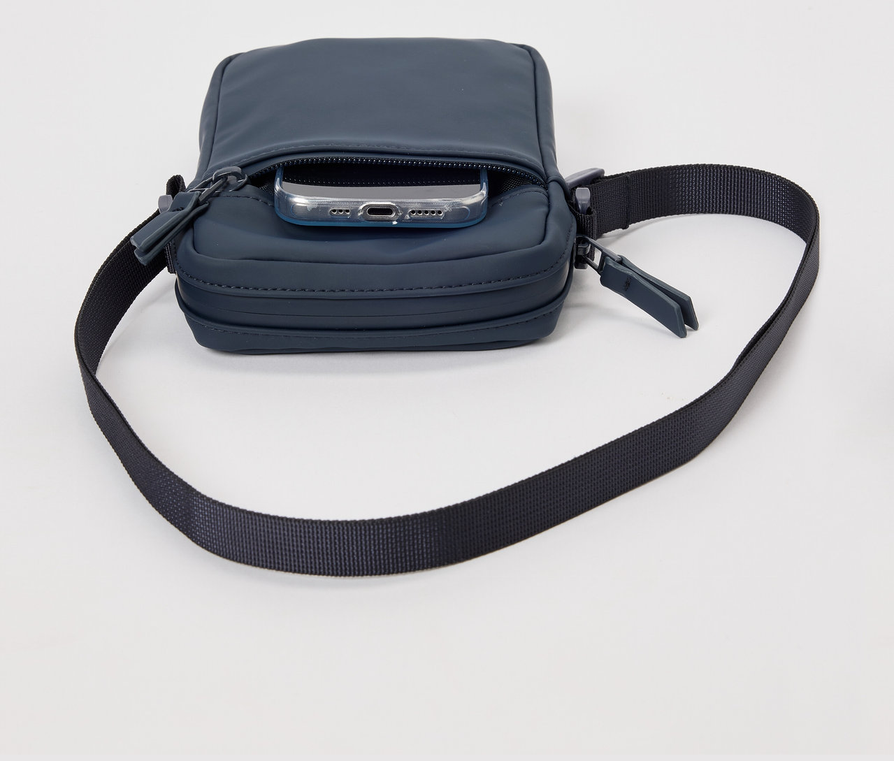 Blaue Regen-Umhängetasche mit Handy in der Tasche.