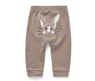 Eine braune Babyhose mit einem gestickten Hasengesicht auf der Rückseite.