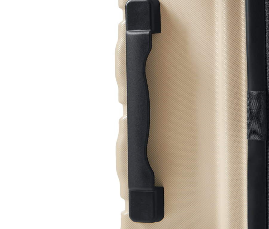 Detailaufnahme eines beigen Hartschalenkoffers mit schwarzem Griff und Reißverschluss.