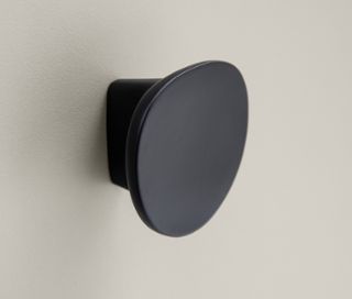 Detailaufnahme eines cremebeigen Highboards »Edda« mit einer Tür und einer Schublade, mit rundem, schwarzen Griff.