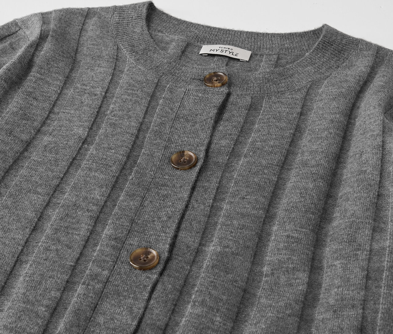 Detailansicht einer grauen Strickjacke mit Knöpfen.