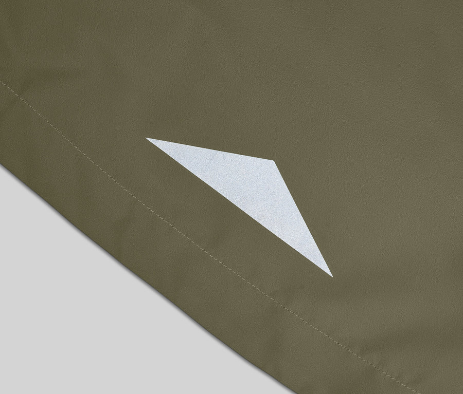 Nahaufnahme eines olivgrünen Stoffes mit einem reflektierenden, dreieckigen Detail und einer Naht.