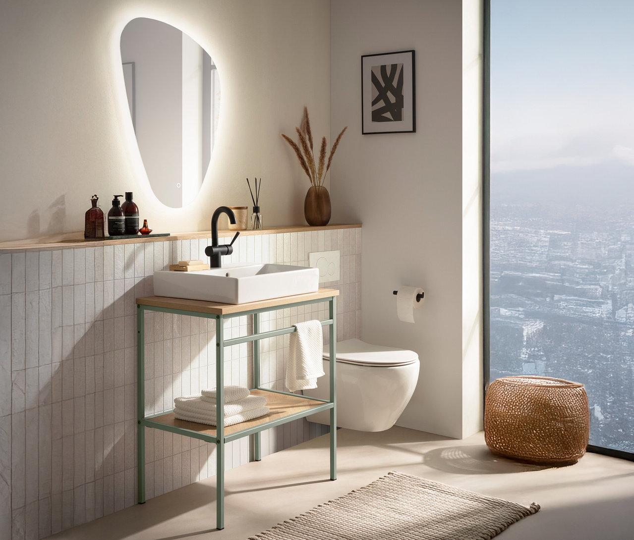 Ein Badezimmer mit einem Waschbecken auf einem grünen Metalltisch, einem beleuchteten Spiegel und einer Toilette an der Wand.