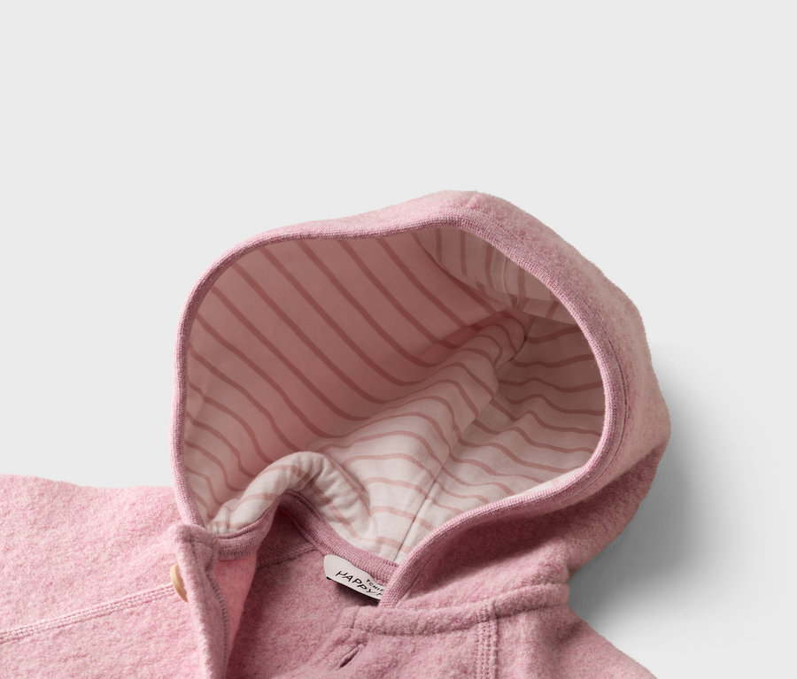 Nahaufnahme einer rosa Wolljacke mit Kapuze, deren Innenseite rosa-weiß gestreift ist.