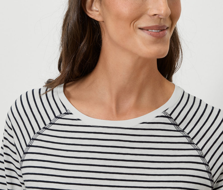 Nahaufnahme einer Frau, die ein gestreiftes Langarmshirt trägt.