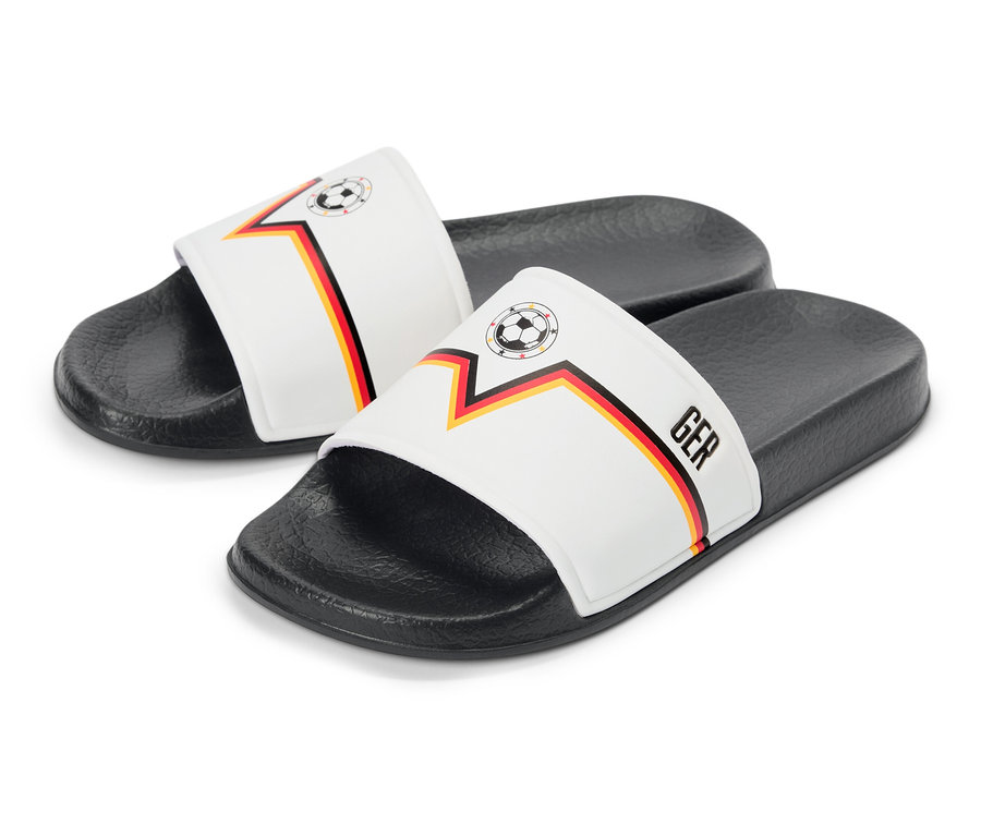 Zwei Deutschland-Sandalen mit Fußball- und Länderflaggen-Design liegen auf einem weißen Hintergrund.