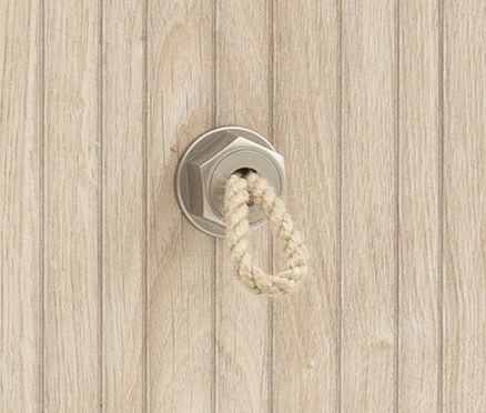 An einer hellbraunen Holzwand ist eine silberne Schraube mit einem Seil befestigt.
