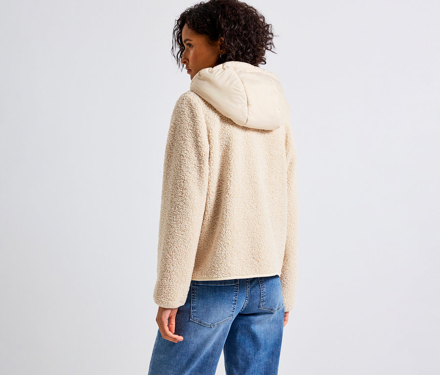 Frau trägt eine beige Street One Teddyjacke mit abnehmbarer Kapuze, kombiniert mit blauen Jeans.