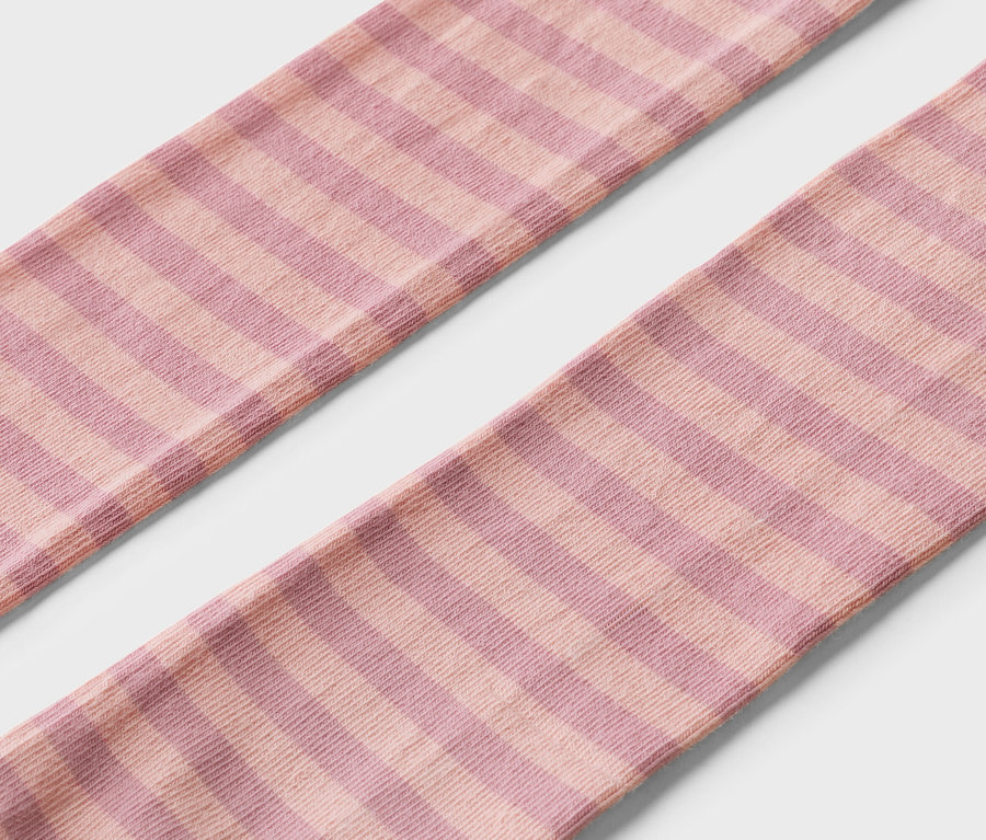 Nahaufnahme von zwei geringelten, rosa-lila gestreiften Strümpfen auf weißem Grund.